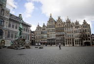 A woman runs though the nearly empty historic center of Antwerp, Belgium, Saturday, March 14, 2020. Belgium has closed schools, restaurants and bars, as as well as cancelled sporting and cultural events in an effort to contain the spread of the coronavirus. For most people, the new coronavirus causes only mild or moderate symptoms, such as fever and cough. For some, especially older adults and people with existing health problems, it can cause more severe illness, including pneumonia. (AP Photo/Virginia Mayo)