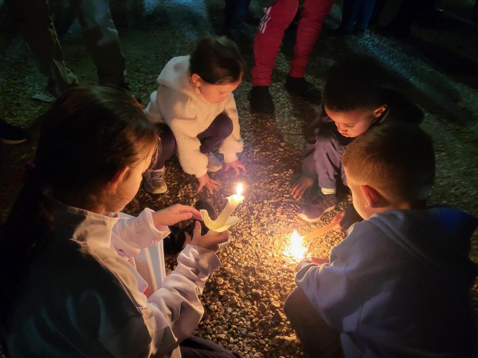 Children light candles during the vigil.