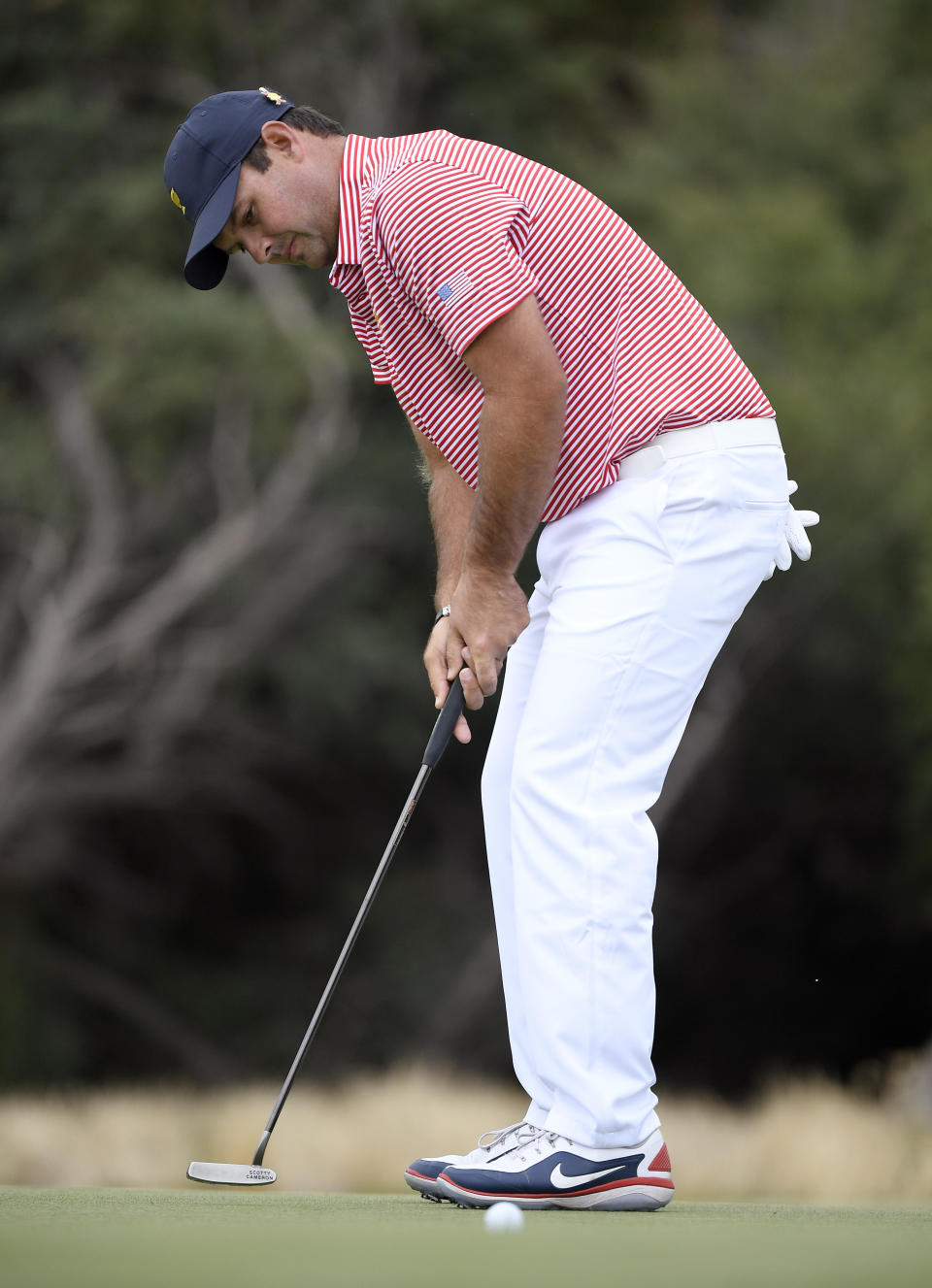 U.S. team player Patrick Reed putts on the 7th green during their fourball match at the Royal Melbourne Golf Club in the opening rounds of the President's Cup golf tournament in Melbourne, Thursday, Dec. 12, 2019. (AP Photo/Andy Brownbill)