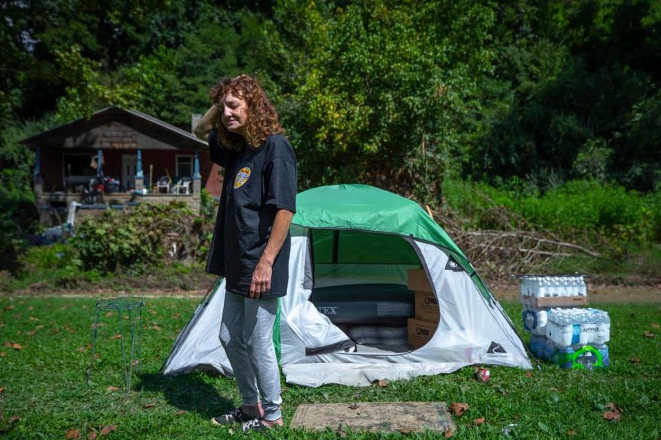 Angela Cornett stands by a tent outside her home that was damaged by flooding last month in Perry County, Kentucky. Cornett lived in the house with her boyfriend, John Jones. They crawled out a window and up a hill behind the house to escape the flood.