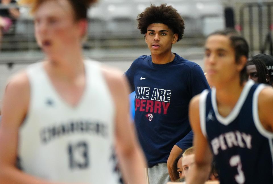 Perry's Koa Peat (in blue) watches from the bench during a game in the Section 7 basketball tournament at State Farm Stadium.