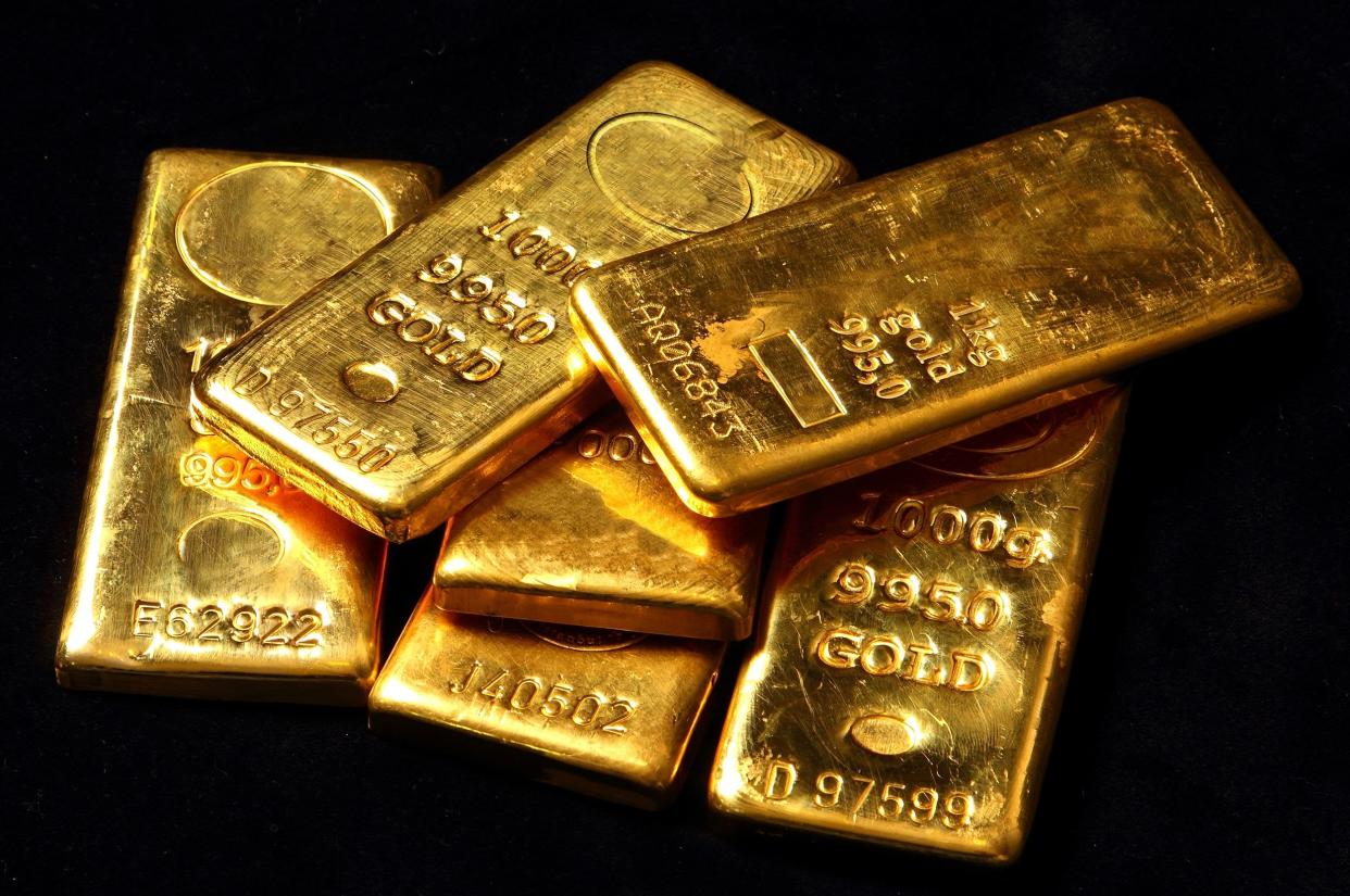 Six 1 kilogram gold bars with black background