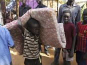 An internally displaced boy carries his belongings inside a United Nations Missions in Sudan (UNMIS) compound in Juba December 19, 2013. South Sudanese government troops battled to regain control of a flashpoint town and sent forces to quell fighting in a vital oil producing area on Thursday, the fifth day of a conflict that that has deepended ethnic divisions in the two-year-old nation. REUTERS/Goran Tomasevic (SOUTH SUDAN - Tags: CIVIL UNREST POLITICS ELECTIONS)