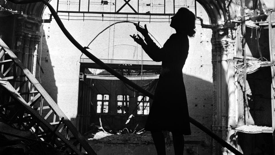 Opera singer Irmgard Seefried singing against the bombed-out Vienna Opera House in November 1945, published in Vogue. - Lee Miller Archives, England 2023