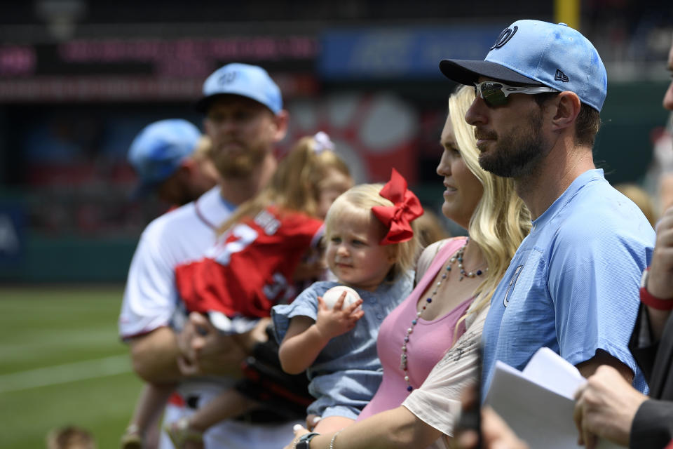 Washington Nationals' Max Scherzer and his wife Erica, second from right, holding their daughter Brooklyn, stand on the field before a baseball game against the Arizona Diamondbacks, Sunday, June 16, 2019, in Washington. (AP Photo/Nick Wass)