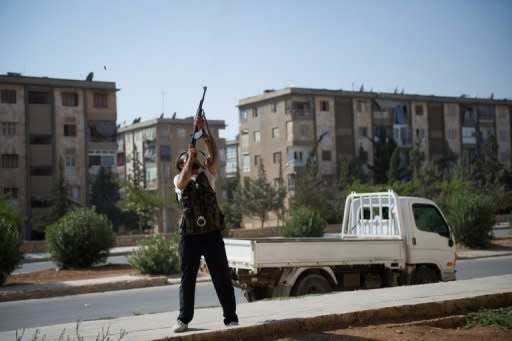 A rebel fighter fires his AK-47 rifle towards a Syrian helicopter in Aleppo's Hanano district. The Syrian army on Monday sent shells slamming into rebel strongholds in Damascus province, where more than 45 people, including 36 civilians, have been killed in the past 48 hours, a watchdog said