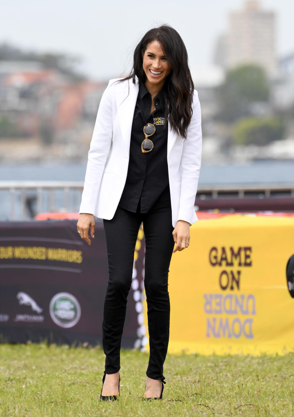<p>For an Invictus Games event on day six of the couple’s Australian royal tour, Meghan teamed a white Altuzarra blazer with an Invictus Sydney shirt. She finished the look with £159 Mother Demin jeans, $240 (approx £184) Illesteva sunglasses and her go-to £566 Tabitha Simmons pumps. <em>[Photo: Getty]</em> </p>