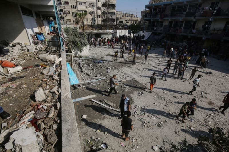 Palestinians inspect the damage after an Israeli airstrike on a school for displaced persons of the United Nations Relief and Works Agency for Palestine Refugees in the Near East (UNRWA) in the Nuseirat refugee camp in the center of the Gaza Strip.  Omar Naaman/dpa