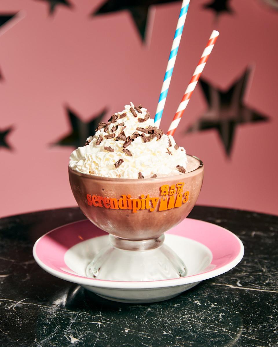 Serendipity 3's Frrrozen Hot Chocolate on a plate with a pink wall full of stars in the background