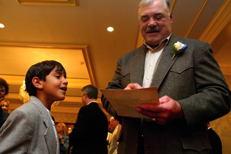 Former Miami Dolphin and Hall of Famer Larry Csonka signs an autograph at the CARP luncheon, where he was guest speaker.