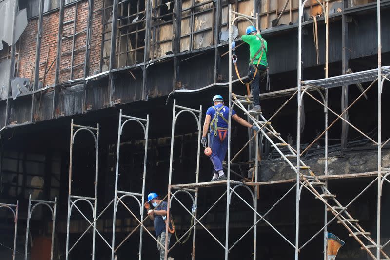 Workers build scaffoldings outside a residential building where a fire broke out in Kaohsiung,