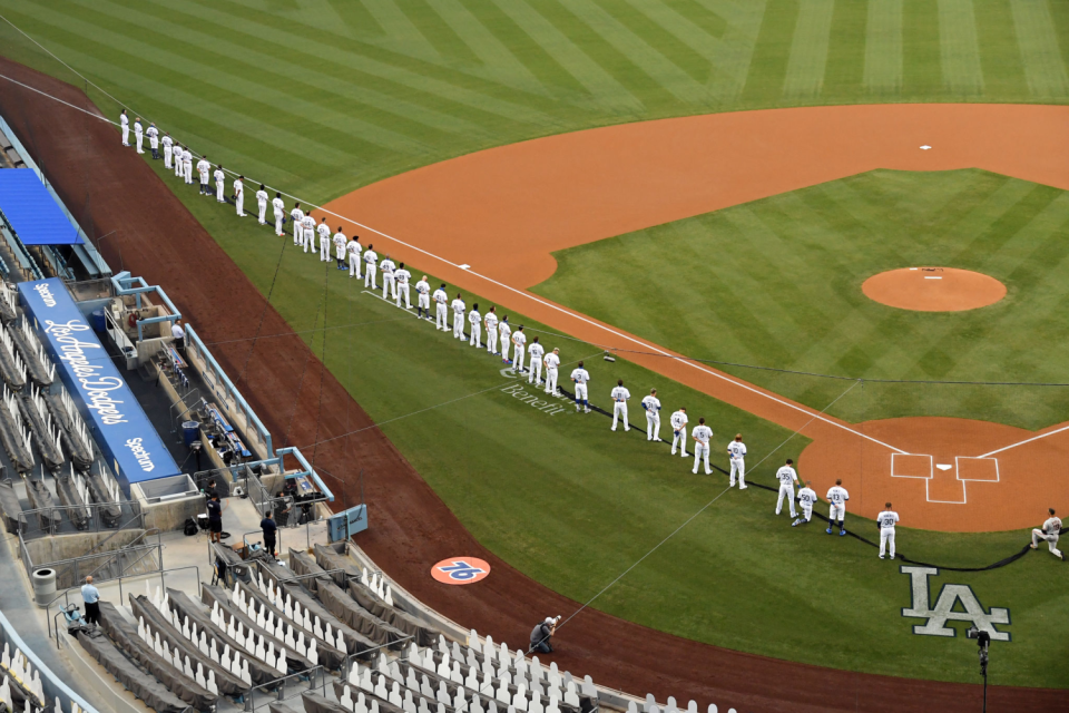 A general view as members of the Los Angeles Dodgers stand for the national anthem as Mookie Betts kneels.