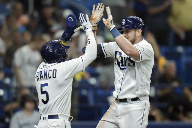 Tampa Bay Rays pitchers Josh Fleming, left to right, Zach Eflin and Shane  McClanahan laugh in the dugout after watching infielder Luke Raley pitch  during a baseball game against the Toronto Blue