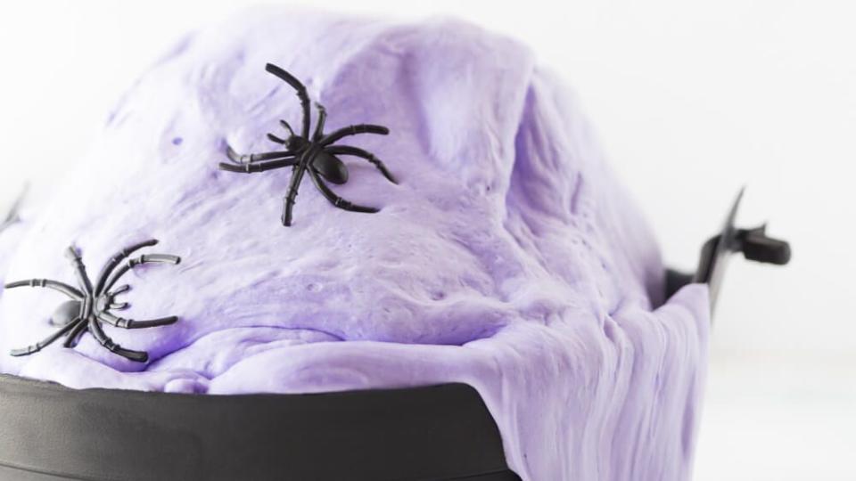 black cauldron overflowing with spiders in fluffy purple slime made for halloween activity