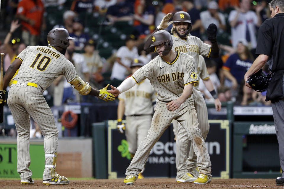 San Diego Padres' Jurickson Profar (10), Wil Myers, center, and Fernando Tatis Jr., right, celebrate a three-run home run by Myers during the 12th inning of a baseball game against the Houston Astros, Saturday, May 29, 2021, in Houston. (AP Photo/Michael Wyke)