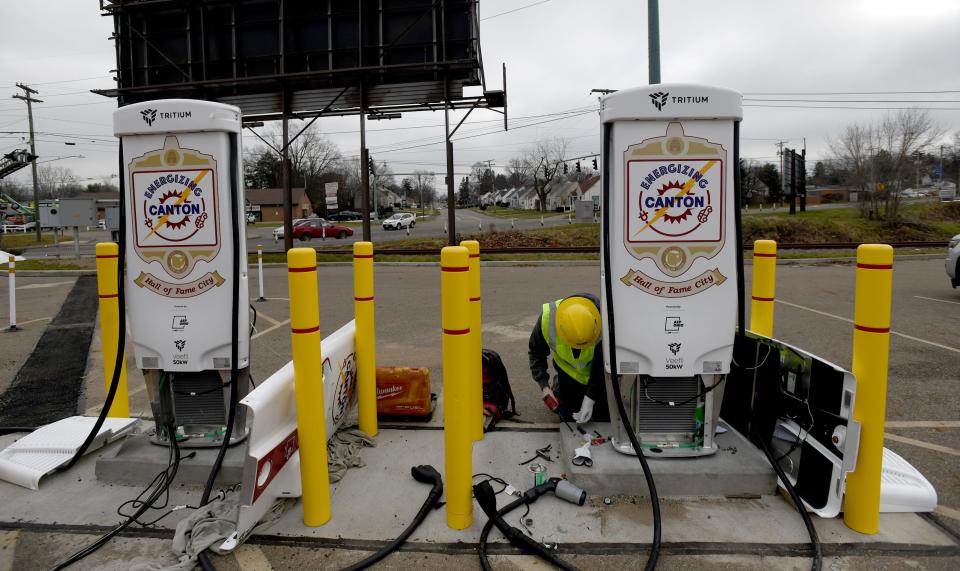 Workers with Hilscher-Clarke Electric Company, including Jack Lewis, install Greenlots electric vehicle charging stations for the city of Canton in the parking lot of Stadium Park.