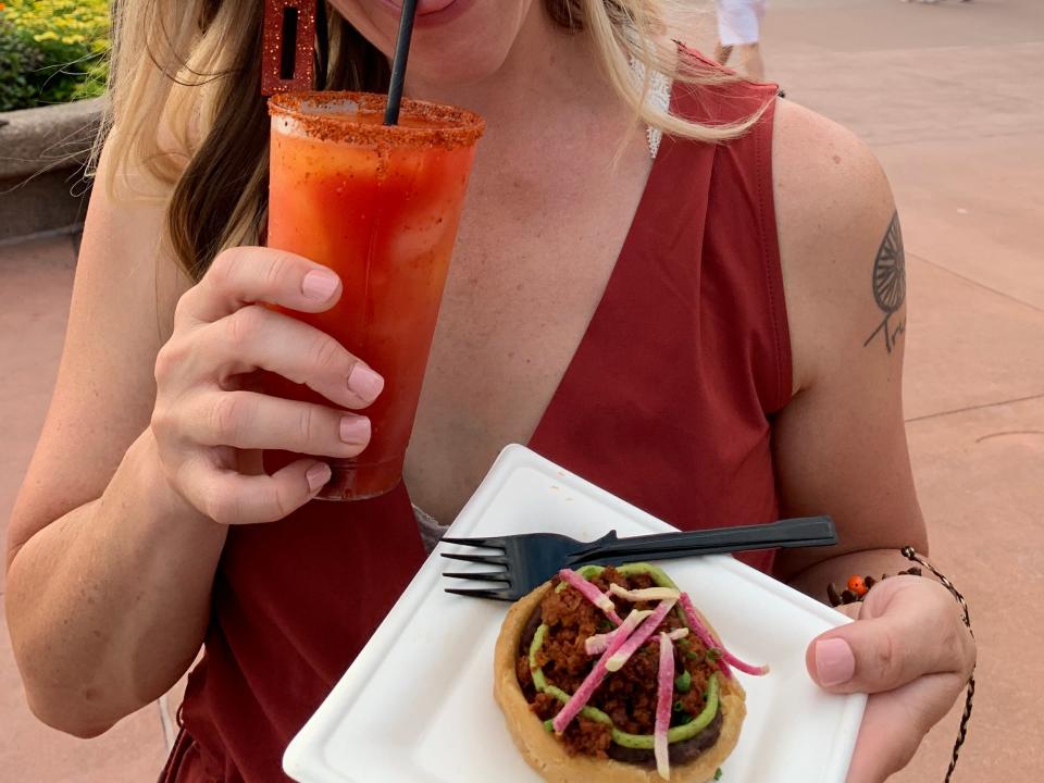 tarah holding food and drink from epcot