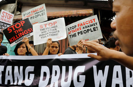 Mourners display placards during a funeral march of Kian delos Santos, a 17-year-old student who was shot during anti-drug operations in Caloocan, Metro Manila, Philippines August 26, 2017. REUTERS/Erik De Castro