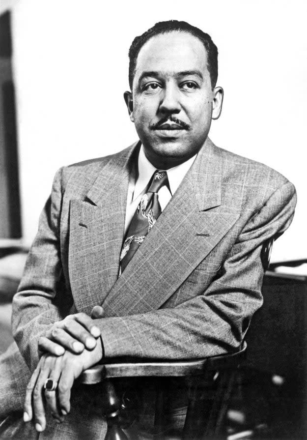 Portrait of Langston Hughes in a suit and tie, seated, looking at the camera