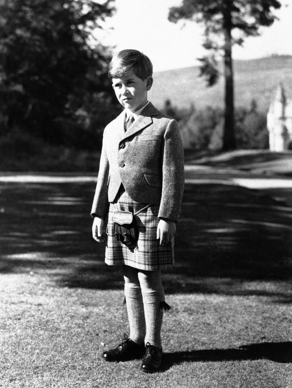 FILE - Britain's Prince Charles poses for a photo, wearing a kilt of Balmoral Tartan on the grounds of Balmoral Castle, in Balmoral, Scotland, Nov. 12, 1955. After waiting 74 years to become king, Charles has used his first six months on the throne to meet faith leaders across the country, reshuffle royal residences and stage his first overseas state visit. With the coronation just weeks away, Charles and the Buckingham Palace machine are working at top speed to show the new king at work. (AP Photo, File)
