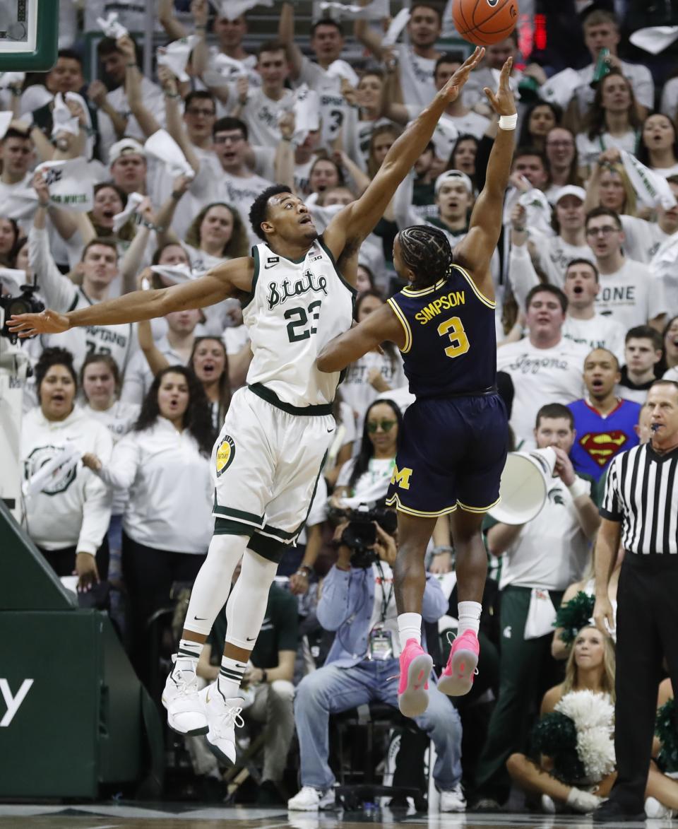 Michigan guard Zavier Simpson (3) releases a hook shot as Michigan State forward Xavier Tillman (23) defends during the first half of an NCAA college basketball game Saturday, March 9, 2019, in East Lansing, Mich. (AP Photo/Carlos Osorio)