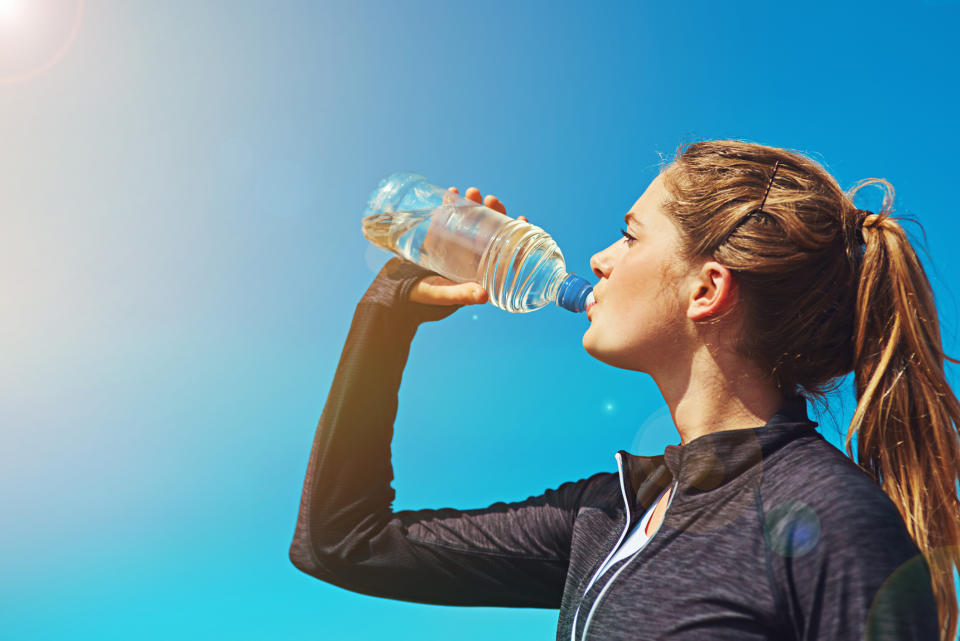 Woman drinking a bottle of water. (Getty Images)