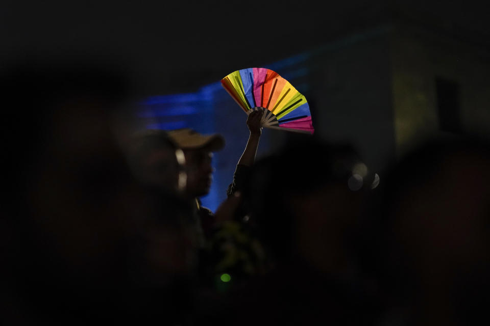 A demonstrator holds a rainbow-colored fan during a protest in Mexico City, Monday, Nov. 13, 2023. The first openly nonbinary person to assume a judicial position in Mexico was found dead in their home Monday in the central Mexican city of Aguascalientes after receiving death threats because of their gender identity, authorities said. (AP Photo/Eduardo Verdugo)