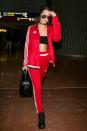 <p>Hadid wears a matching Adidas tracksuit to the airport paired with black boots, sunglasses, and a handbag. (Photo: Getty) </p>