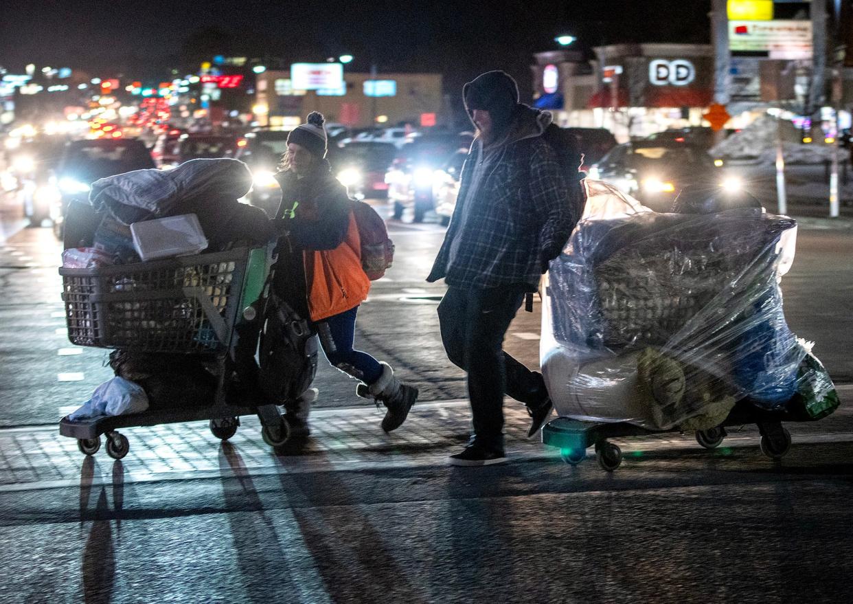 Samantha Olney and David Koukoulis cross busy Route 9 with their belongings in shopping carts on a recent night.