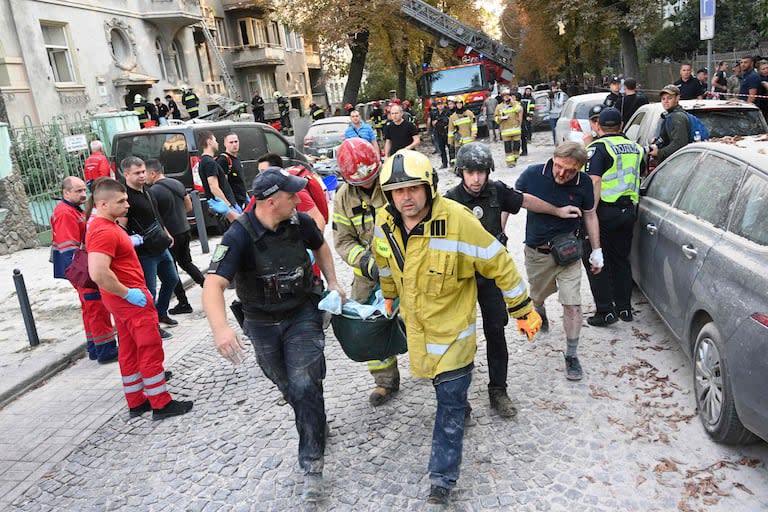 Rescatistas y policías ucranianos llevan el cuerpo de una persona muerta tras un ataque con misiles en Lviv el 4 de septiembre de 2024