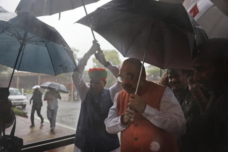 Indian Home Minister Amit Shah, center front, arrives at the Parliament in New Delhi, India, Tuesday, Aug.6, 2019. India's lower house of Parliament was set to ratify a bill that would downgrade the governance of India-administered, Muslim-majority Kashmir. (AP Photo/Manish Swarup)