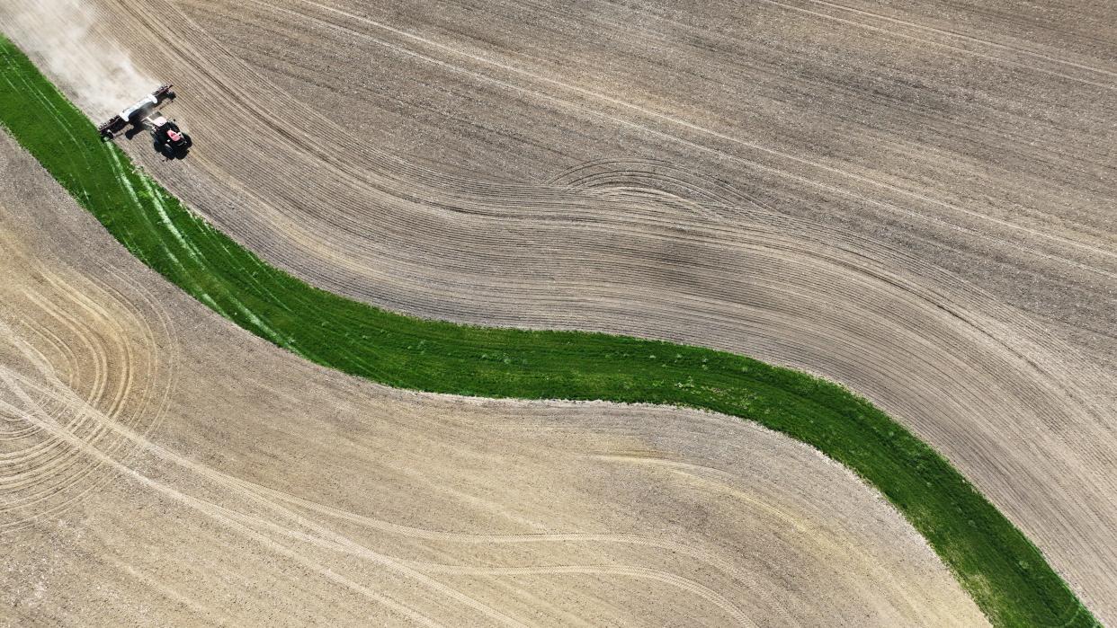 Planting season has begun for Ohio farmers, including Jon Miller of Fairfield County. Miller can be seen from above, moving his tractor and soybean planter along a creek bed on his farm near Pleasantville.