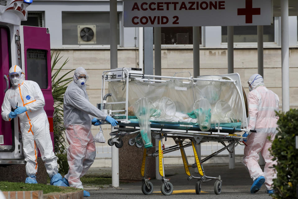 A patient in a biocontainment unit is carried on a stretcher from an ambulance arrived at the Columbus Covid 2 Hospital in Rome, Tuesday, March 17, 2020.  For most people, the new coronavirus causes only mild or moderate symptoms. For some it can cause more severe illness, especially in older adults and people with existing health problems. (AP Photo/Alessandra Tarantino)