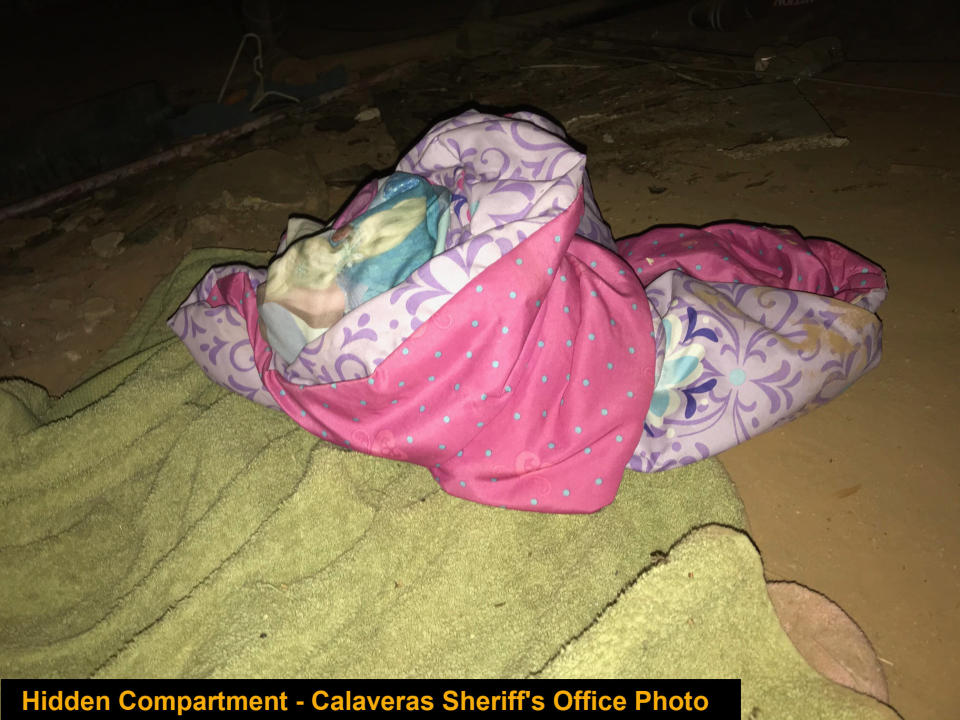 Pink bedding in the makeshift sleeping space on the dirt floor.