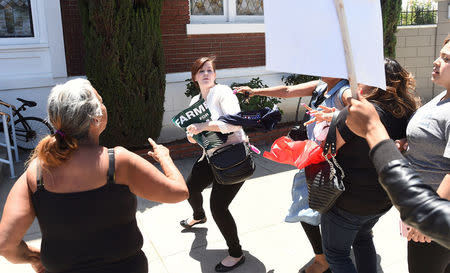 Protesters confront a woman, center, leaving a rally for Republican U.S. presidential candidate Donald Trump in Fresno, California, U.S. May 27, 2016. REUTERS/Noah Berger