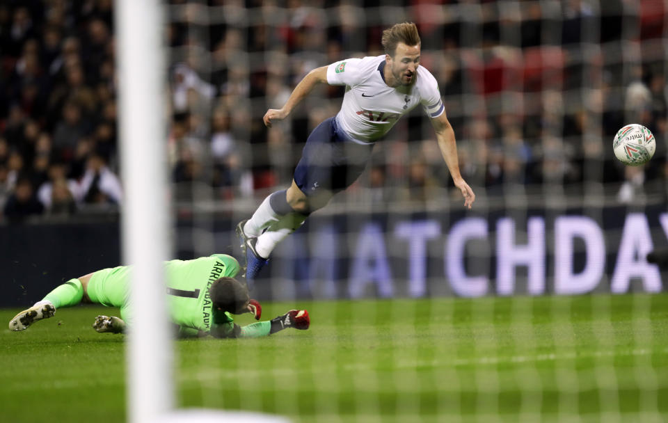 Tottenham's Harry Kane, falls as he challenges, Chelsea's goalkeeper Kepa Arrizabalaga during the English League Cup semifinal first leg soccer match between Tottenham Hotspur and Chelsea at Wembley Stadium in London, Tuesday, Jan. 8, 2019. (AP Photo/Kirsty Wigglesworth)