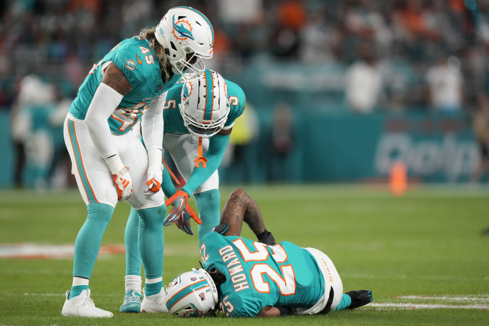 Miami Dolphins linebacker Duke Riley (45) and cornerback Jalen Ramsey (5) check on cornerback Xavien Howard (25) during the first half of an NFL football game against the Tennessee Titans, Monday, Dec. 11, 2023, in Miami, Fla. (AP Photo/Rebecca Blackwell)