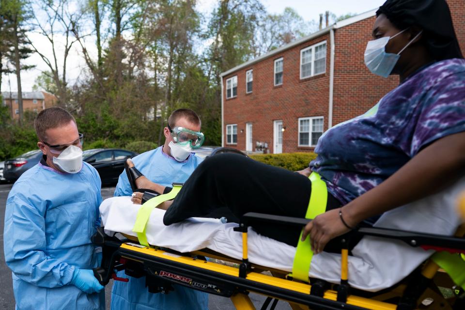 Paramedics and firefighters with Anne Arundel County Fire Department load a confirmed COVID-19 patient onto the ambulance on April 21, 2020 in Glen Burnie, Maryland. (Photo by Alex Edelman / AFP) / RESTRICTED TO EDITORIAL USE (Photo by ALEX EDELMAN/AFP via Getty Images)