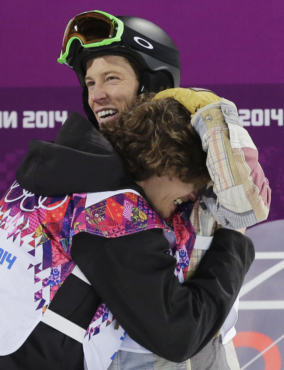 Switzerland's Iouri Podladtchikov, bottom, celebrates with Shaun White of the United States after Podladtchikov won the gold medal in the men's snowboard halfpipe final at the Rosa Khutor Extreme Park, at the 2014 Winter Olympics, Tuesday, Feb. 11, 2014, in Krasnaya Polyana, Russia. (AP Photo/Andy Wong)