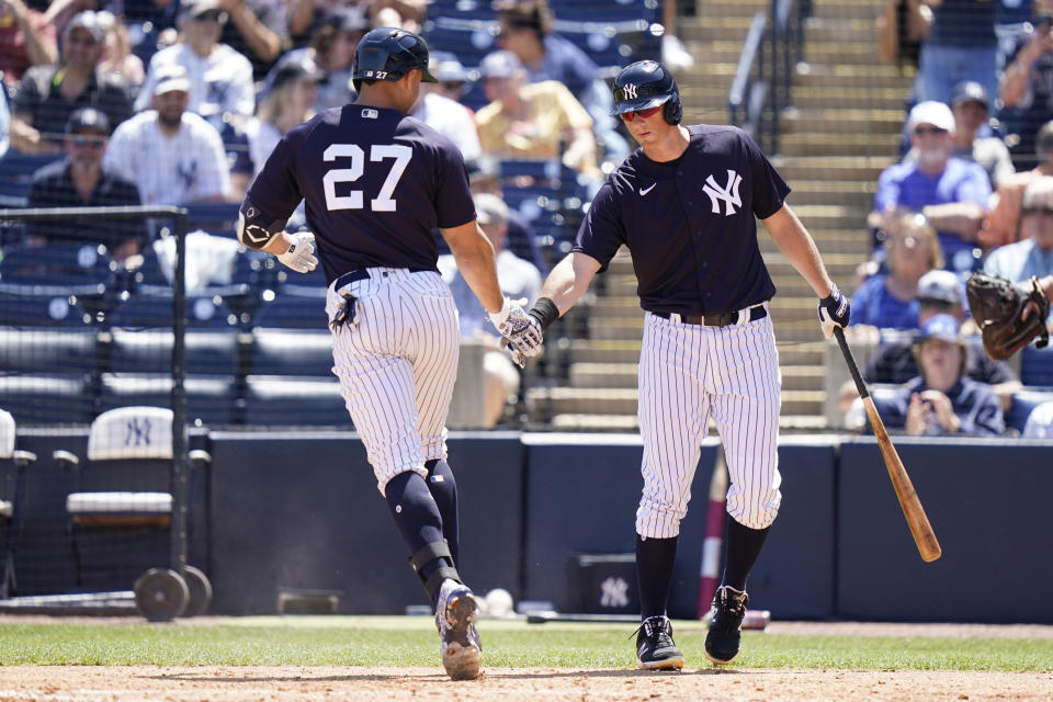 New York Yankees' Giancarlo Stanton (27) is greeted by DJ LeMahieu, right, after hitting a solo home run in the fourth inning of a spring training baseball game against the Toronto Blue Jays, Saturday, March 26, 2022, in Tampa, Fla. (AP Photo/Lynne Sladky)