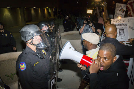 Protesters confront police outside the Phoenix Police Department the week after an unarmed man was shot dead by police, in Phoenix, Arizona December 8, 2014.