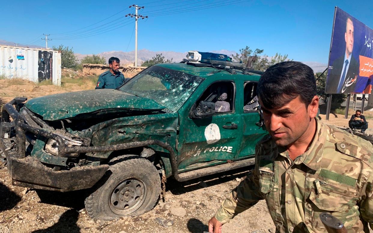 Afghan police inspect the site of the suicide attack in Parwan province - AP
