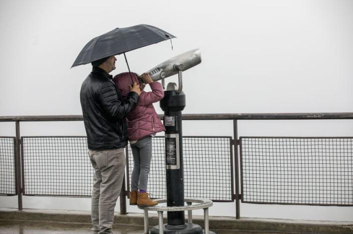 LOS ANGELES, CA-DECEMBER 30, 2022: Leia Capote, 6, with her father, Luis, 40, doesn't have much to look at do to inclement weather, outside the Griffith Observatory in Los Angeles. They are visiting from Miami, Florida.(Mel Melcon / Los Angeles Times)