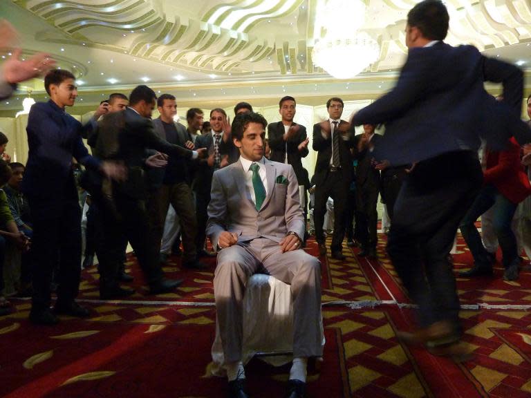 Afghan men dance around the groom during celebrations at a wedding hall in Kabul