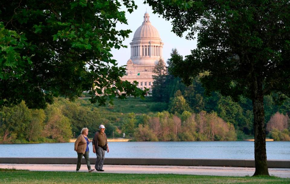 A couple walks along Capitol Lake in Olympia, Washington, on Friday, July 2, 2021.