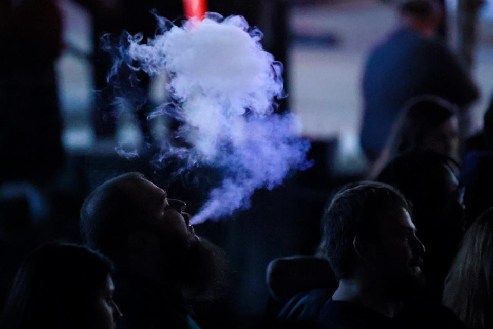 A fan vapes during a Micro Wrestling event Friday, Feb. 11, 2022 at That Bar at the Arena in Jacksonville. Hundreds came out to watch people who are little, battle each other in an outdoor, pro wrestling, WWE-style event. [Corey Perrine/Florida Times-Union]