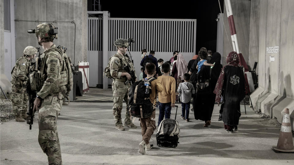 U.S. troops with the 82nd Airborne Division escort evacuees to buses at the airport in Kabul on Aug. 25, 2021.