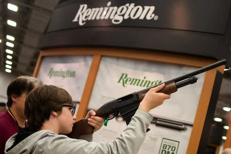A boy aims a Remington firearm at the annual National Rifle Association (NRA) meeting in Dallas, Texas, U.S., May 4, 2018. REUTERS/Adrees Latif