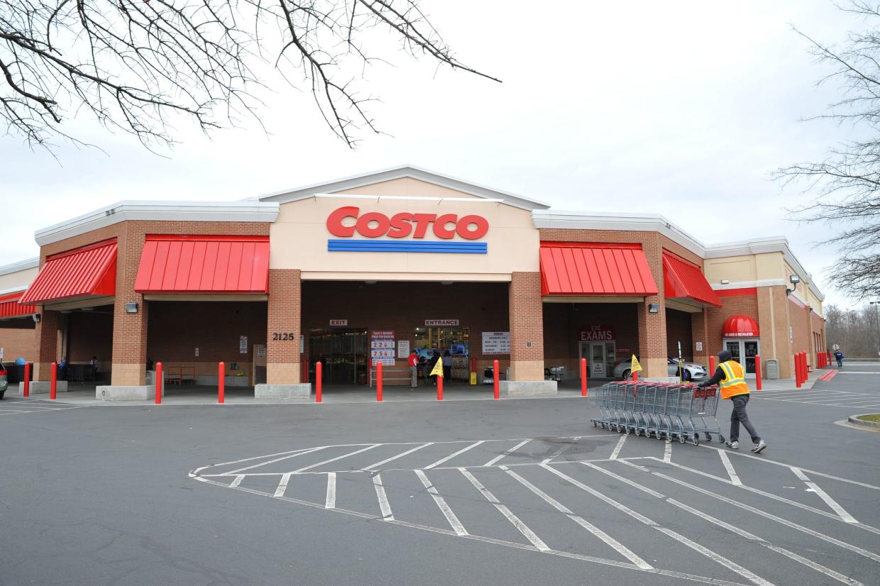 A Costco worker pushing shopping carts towards Costco Wholesale store in Matthews, North Carolina.