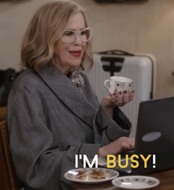 Catherine O'Hara in "Schitt's Creek" holding a cup and saying "I'm busy!"